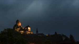 a storm rages over a Gothic castle
